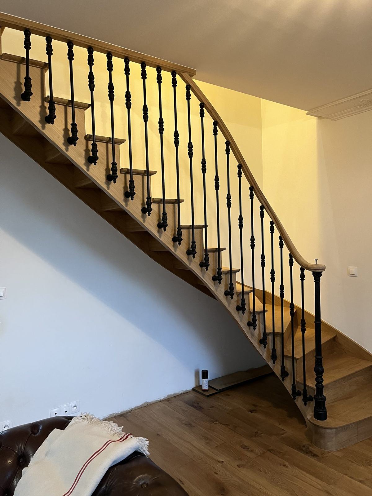 Escalier quart tournant en chêne, main courante cintrée et balustres en fer forgé