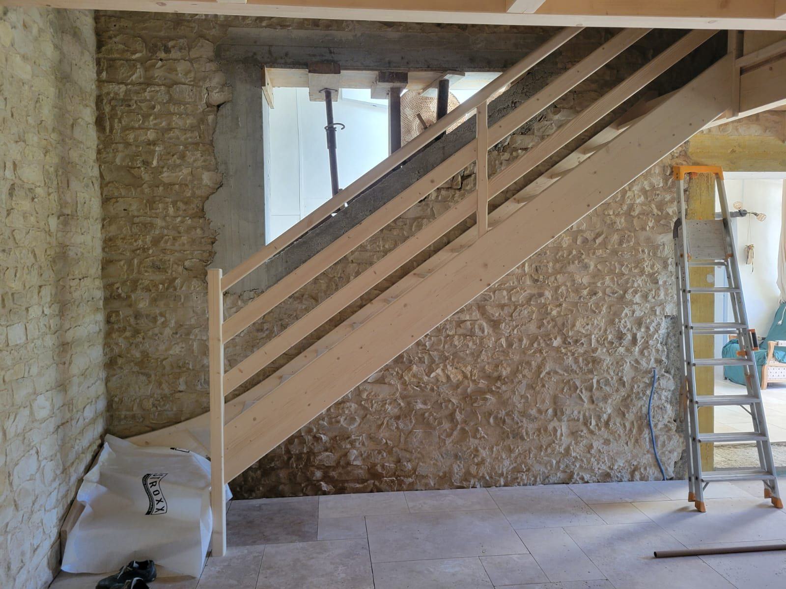Escalier posé le long d’un mur de pierre