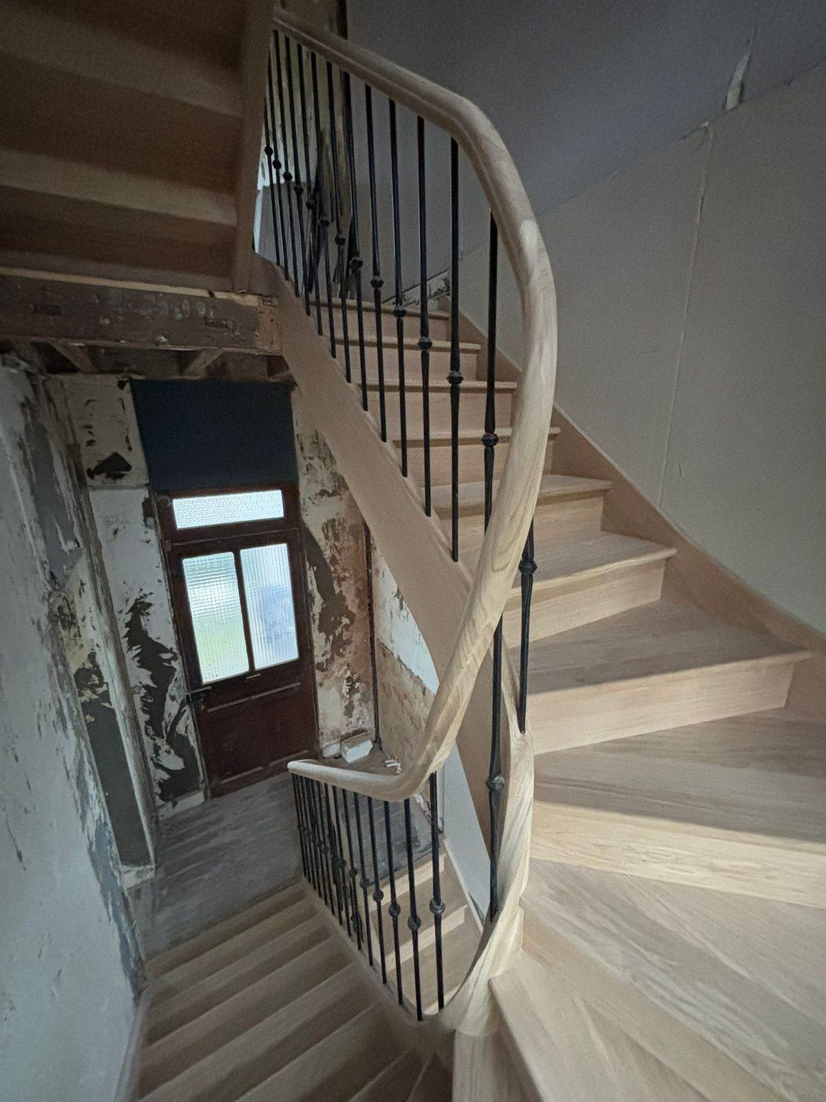 Escalier cintré en chêne, balustres en fer forgé, maison ancienne